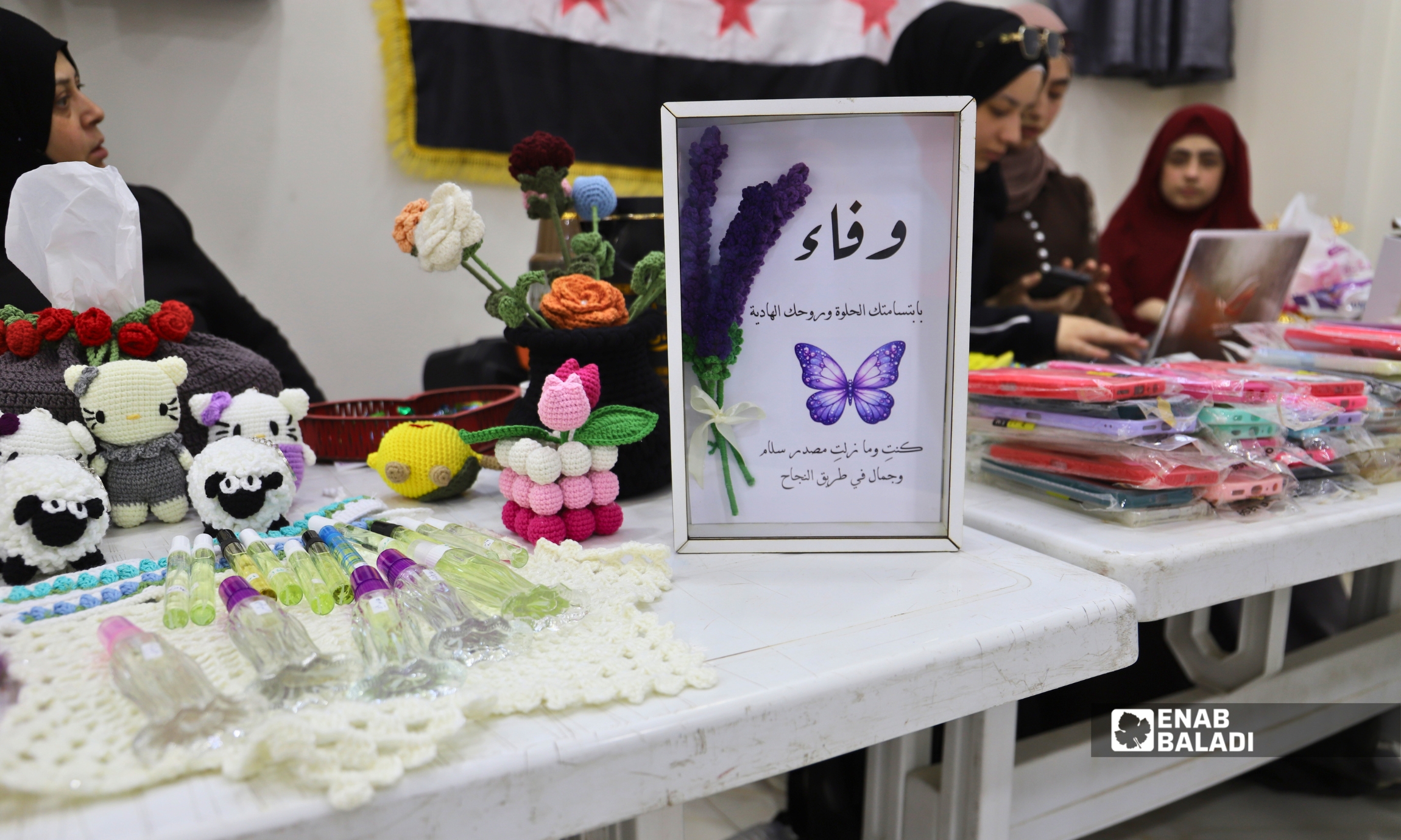 نساء يعرضن منتجات المشاريع المنزلية خلال بازار "نساء داريا" في المركز الثقافي بمدينة داريا