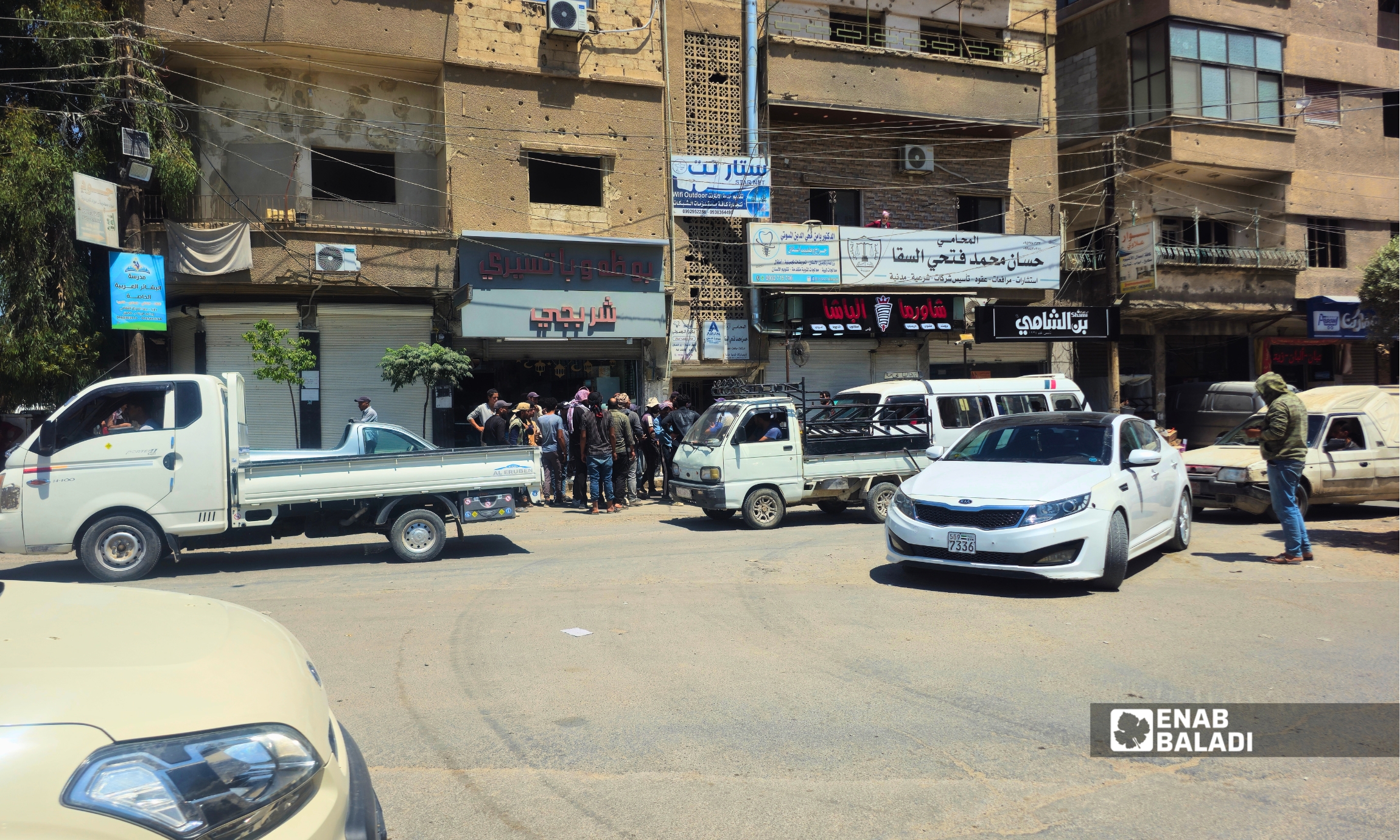 تجمع عمال العتالة في ساحة الترب بانتظار وصول سيارات تحميل البضائع في مدينة داريا 