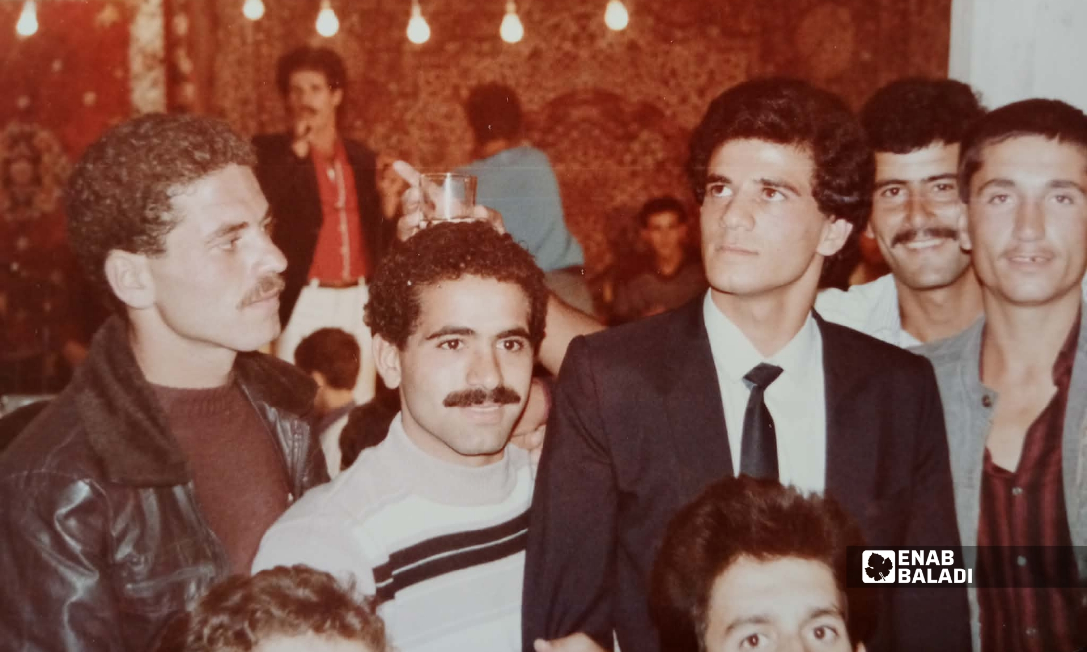 محمد كامل خلال زفافه في داريا عام 1986، وتظهر خلفه منصة الفرقة الموسيقية والمغنون المشاركون (عنب بلدي - أرشيف محمد كامل)