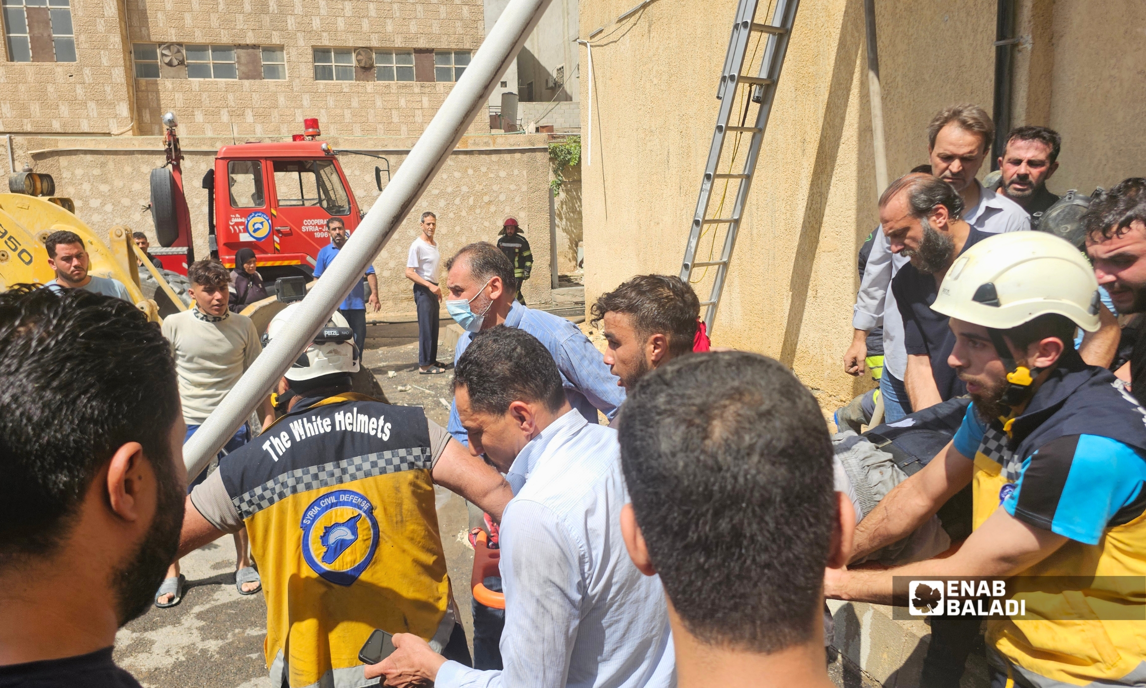فرق الدفاع المدني خلال إخماد حريق مشغل للخياطة على طريق المعامل في مدينة داريا