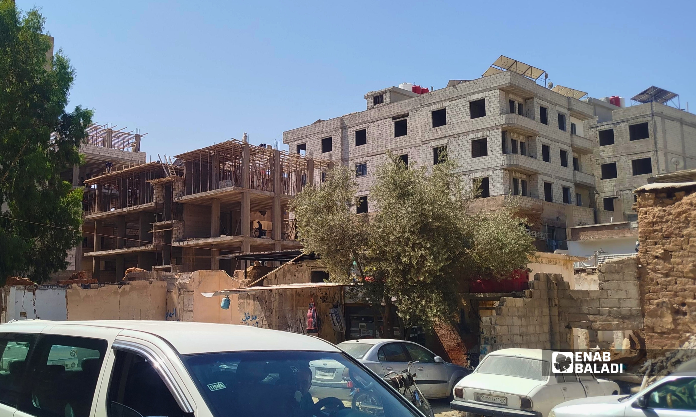 ورشة بناء وسط أبنية سكنية متفاوتة الارتفاع في مدينة داريا