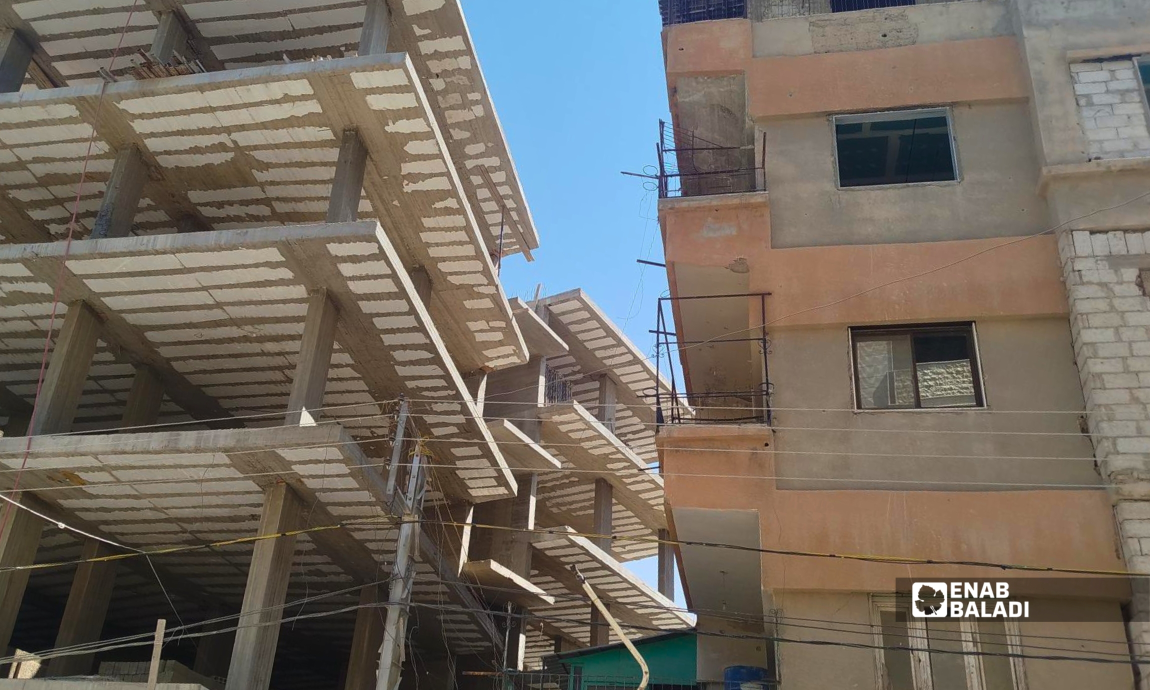 ورشة بناء وسط أبنية سكنية متفاوتة الارتفاع في مدينة داريا