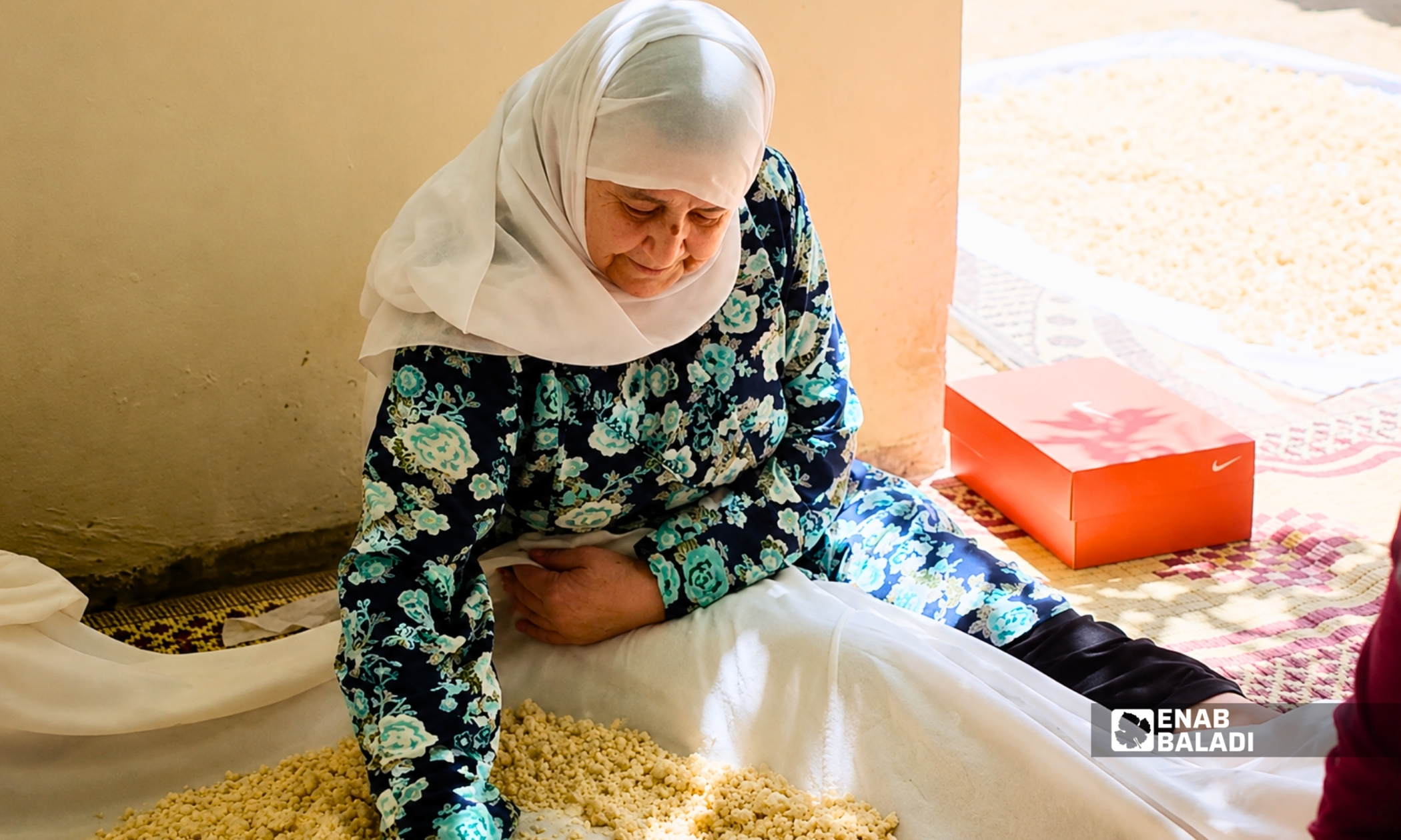 السيدة مفيدة العبار خلال مشاركتها في إعداد الكشك بداريا (عنب بلدي)