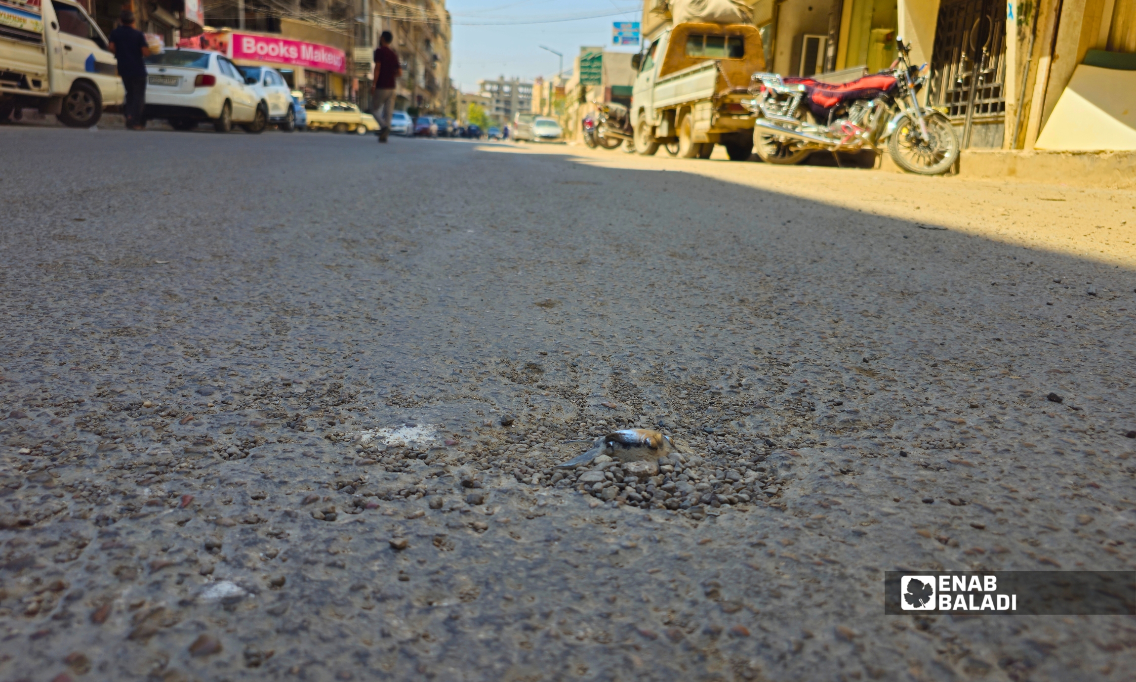 الجزء الظاهر من قذيفة هاون غير منفجرة في أرض شارع الثورة بمدينة داريا