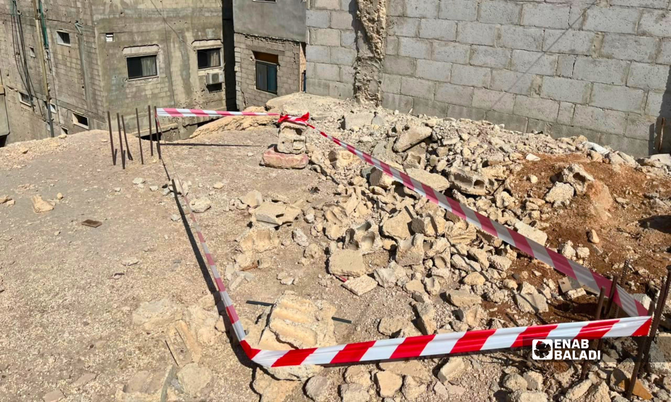 فريق من الدفاع المدني يعاين مخلفات حرب على سطح بناء قرب جامع العباس في مدينة داريا