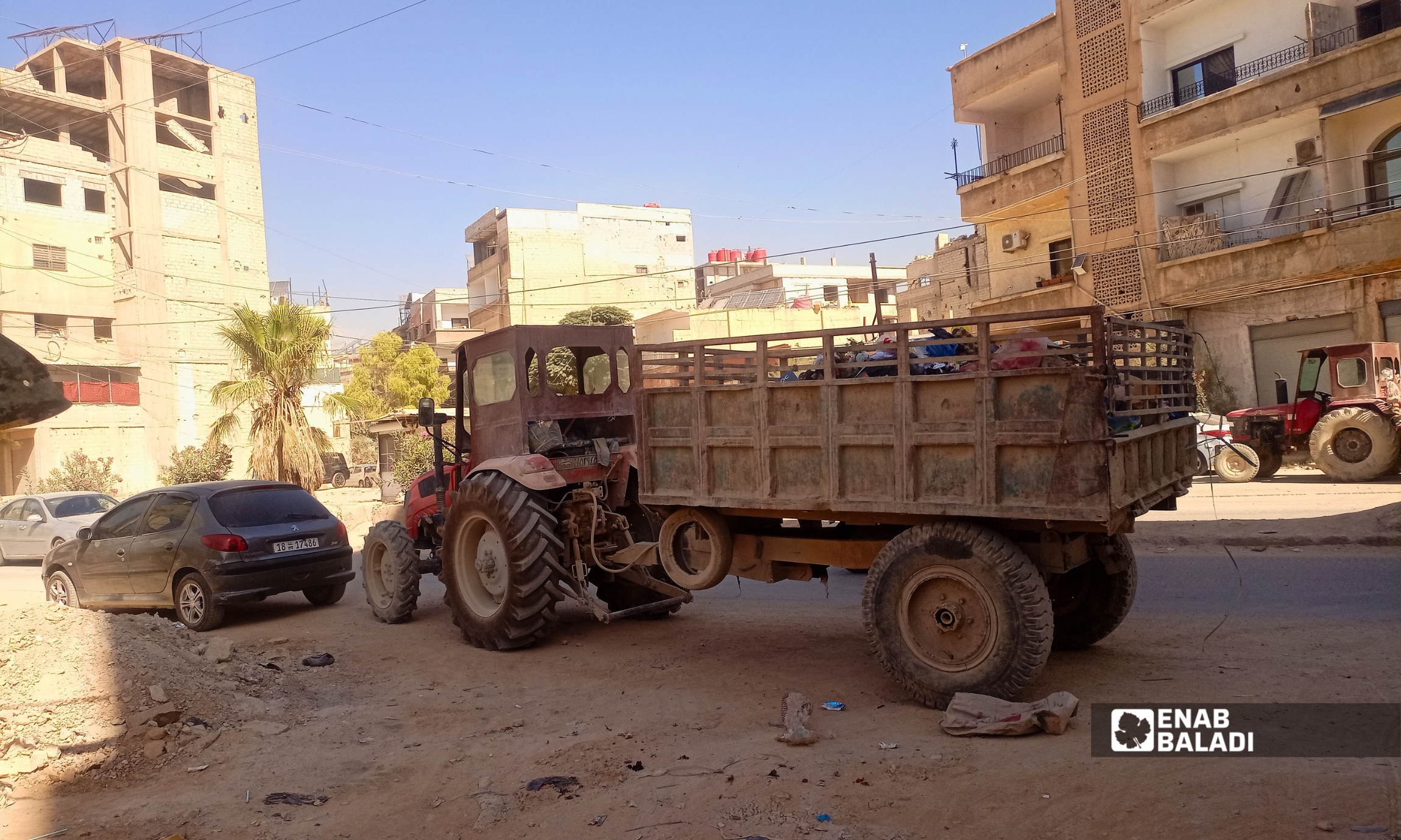 عمال النظافة يرفعون كومة من النفايات في أحد شوارع داريا