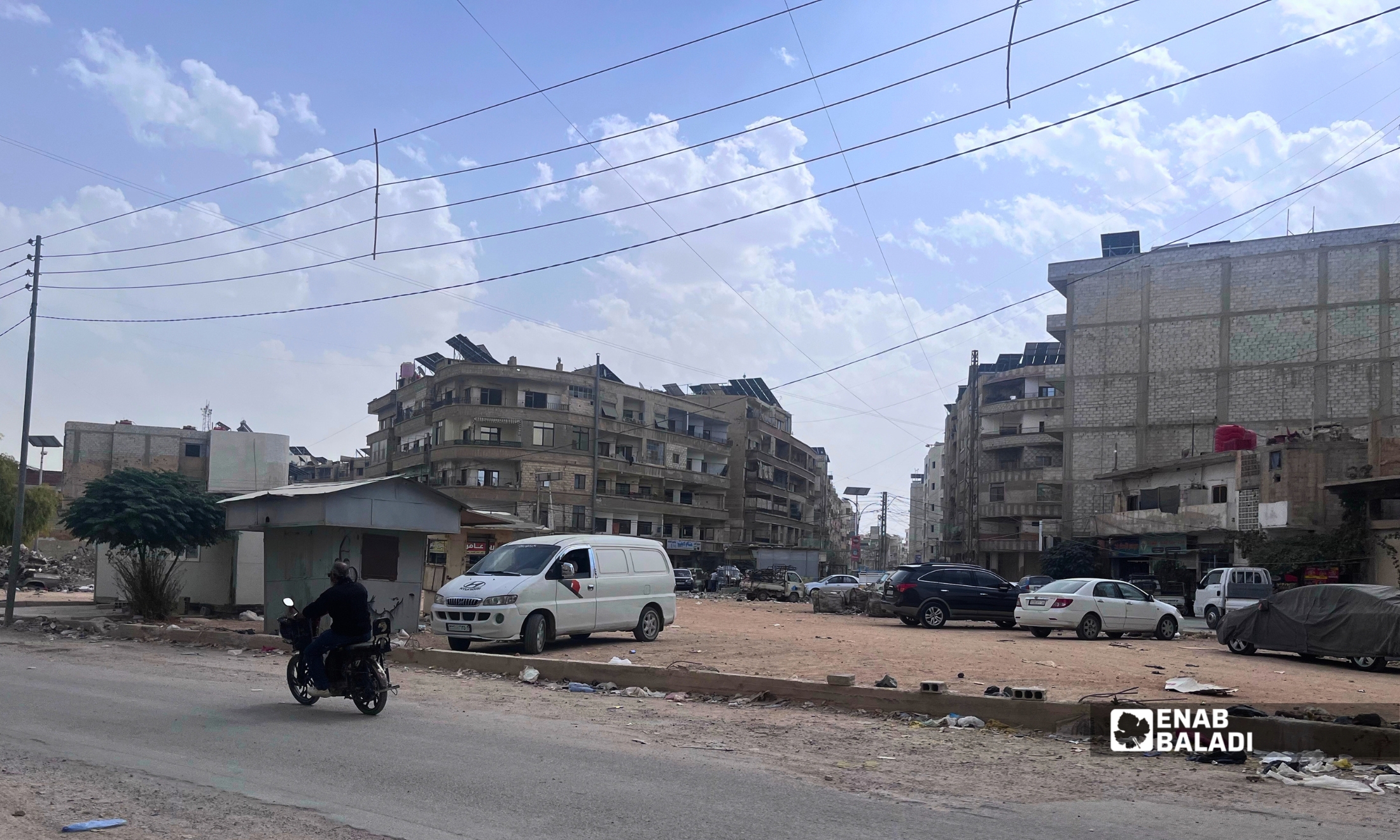 أسلاك كهرباء ممتدة بين الأبنية والمحال التجارية في ساحة شريدي بداريا 
