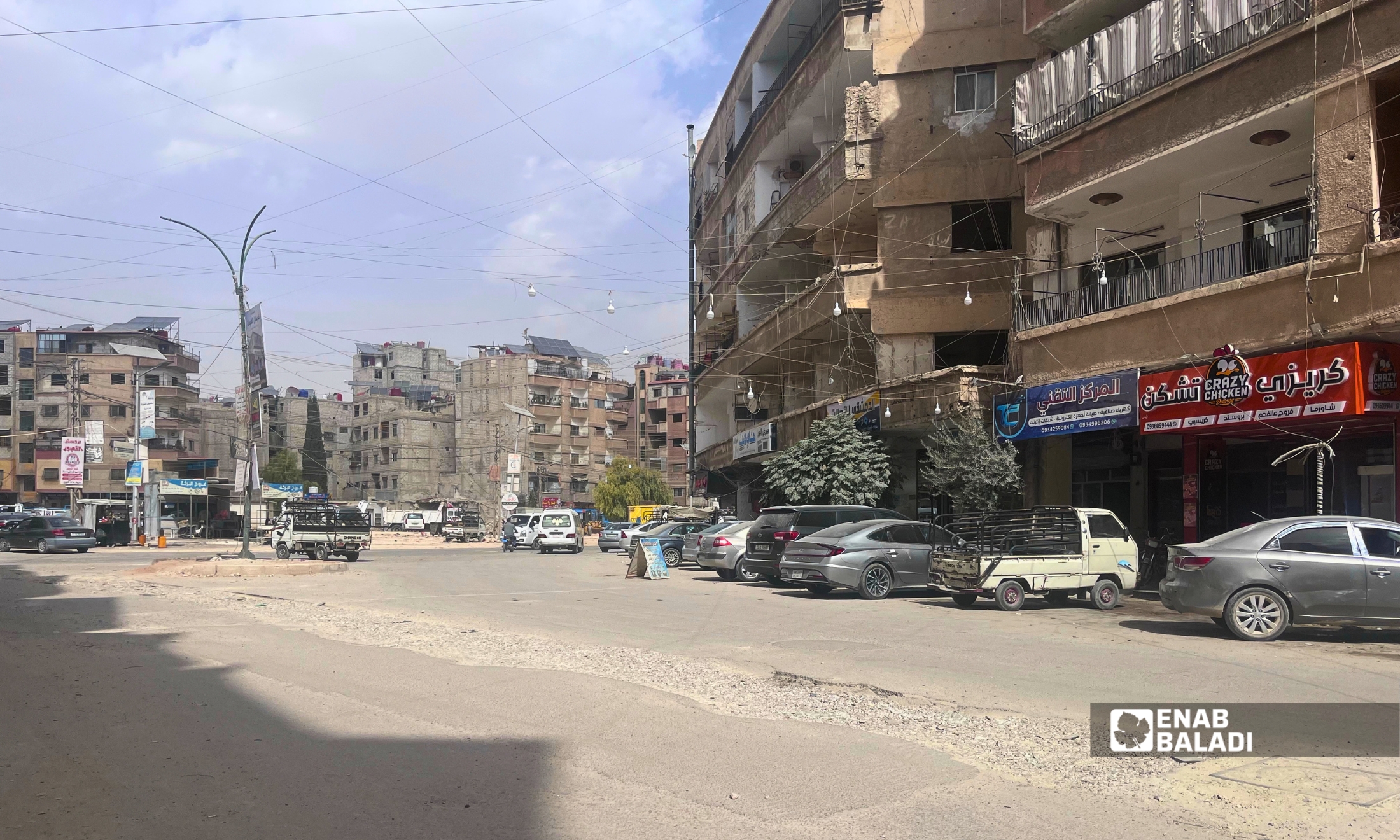 أسلاك كهرباء ممتدة بين الأبنية والمحال التجارية في ساحة شريدي بداريا 