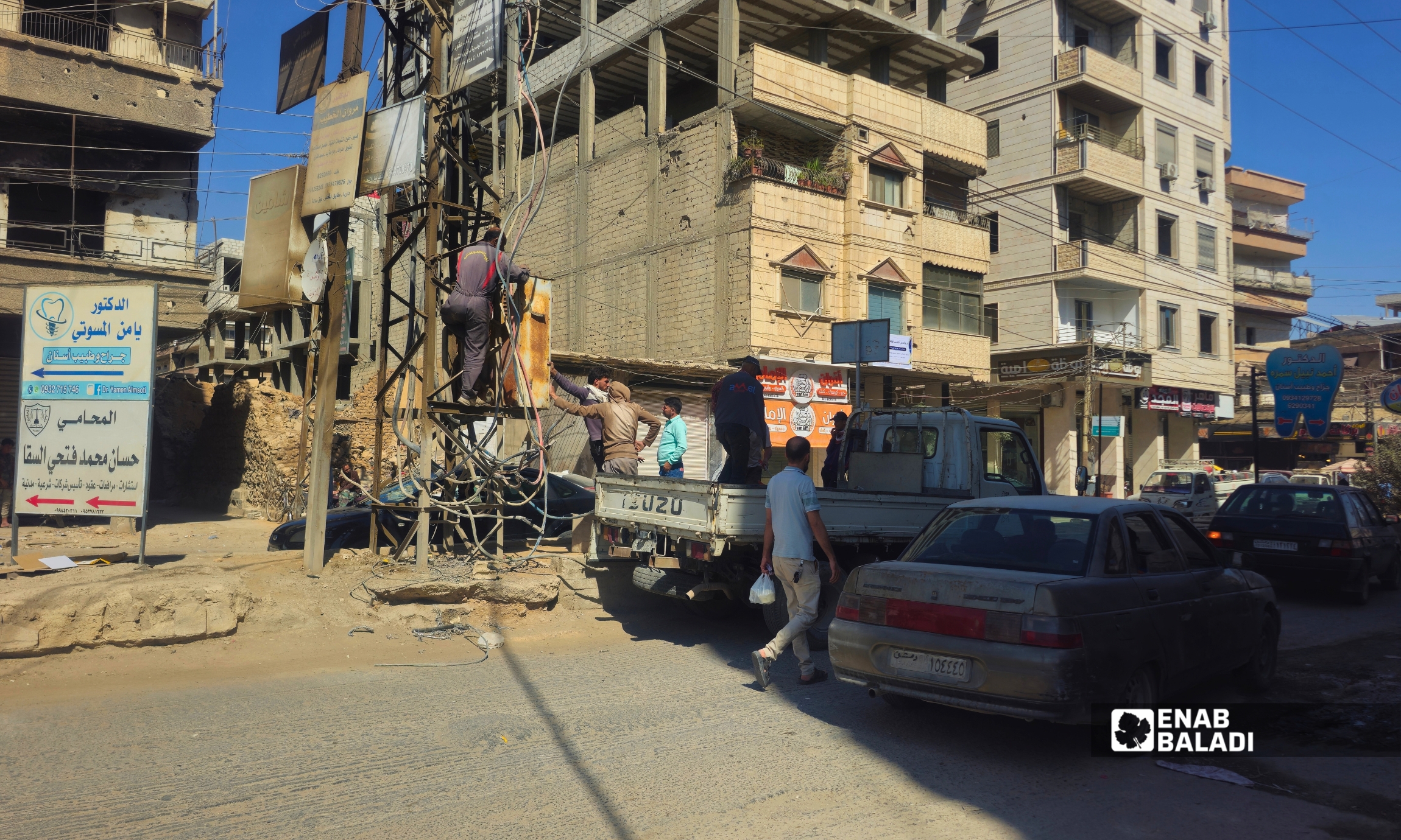 عمال طوارئ الكهرباء يستبدلون لوحة كهربائية في داريا 