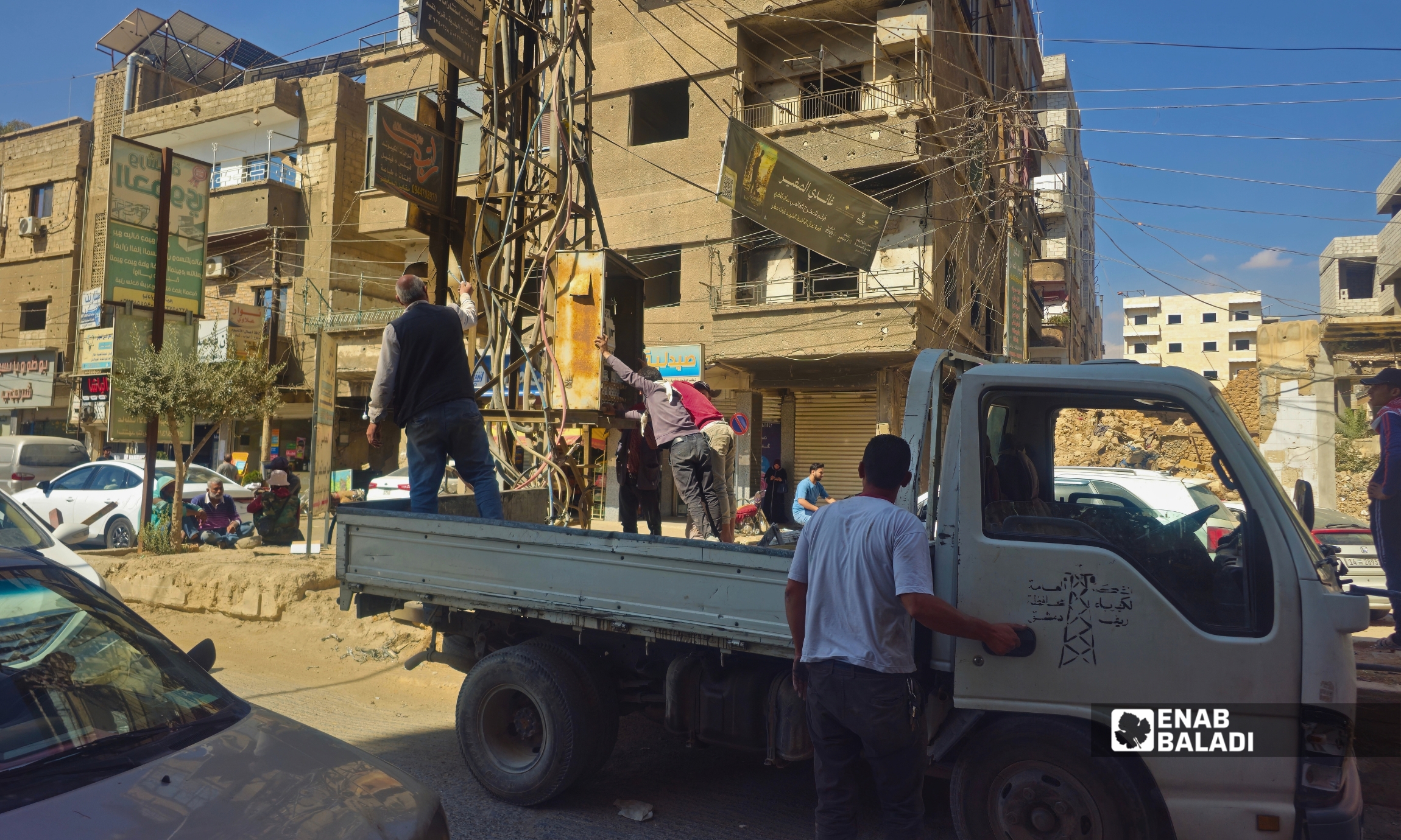 عمال طوارئ الكهرباء يستبدلون لوحة كهربائية في داريا 