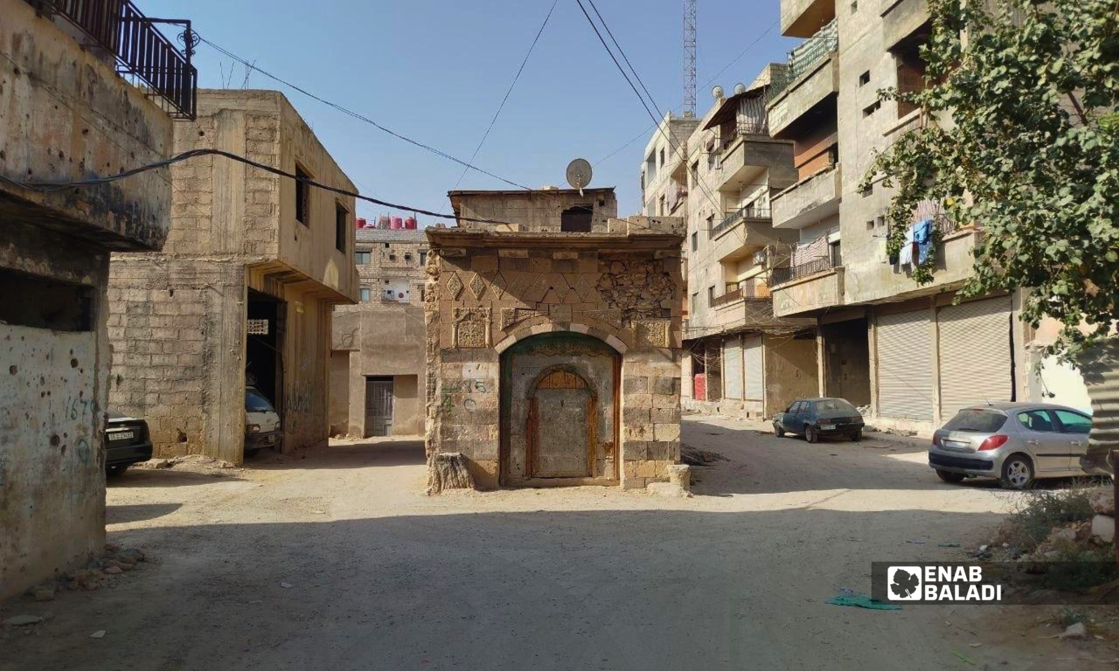 عمود وتمديدات كهربائية بين أبنية سكنية في مدينة داريا