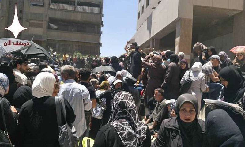 (Crowds of hundred people gathering in front of a Charity building in Al-Maydan neighborhood in the city of Damascus – June, 10th, 2016 – Damascus Now)