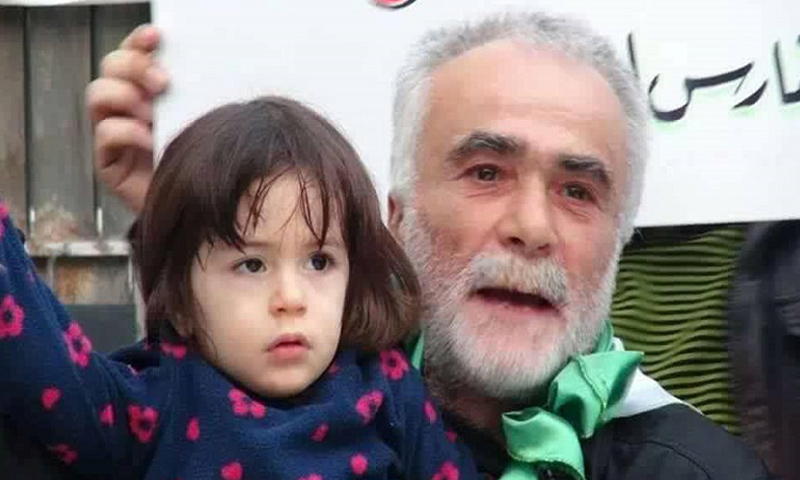 Abu Majid Karman holding his granddaughter in a demonstration in Aleppo (Archive)