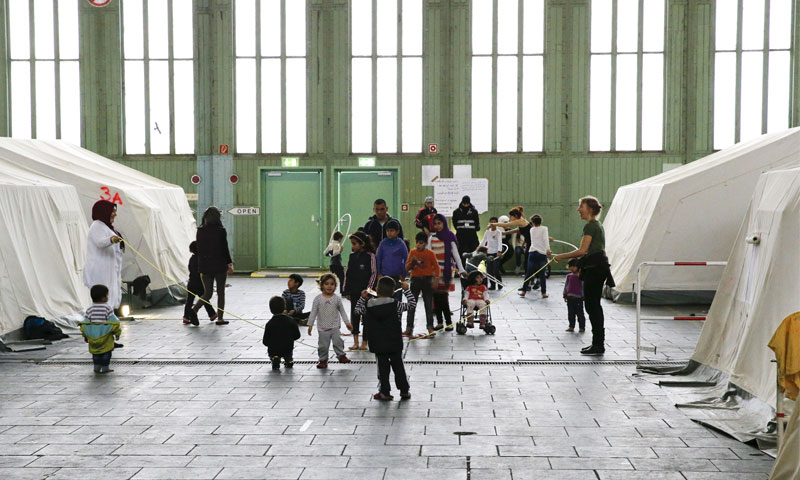 Syrian refugee children playing next to tents at a shelter for migrants in Berlin’s Tempelhof airport, Germany, 9 November 2015 (Reuters)