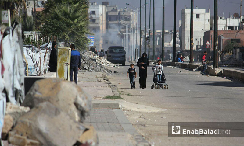 A woman with her children in the besieged al-Waer Neighborhood in the city of Homs, 4 February 2017 (Enab Baladi)