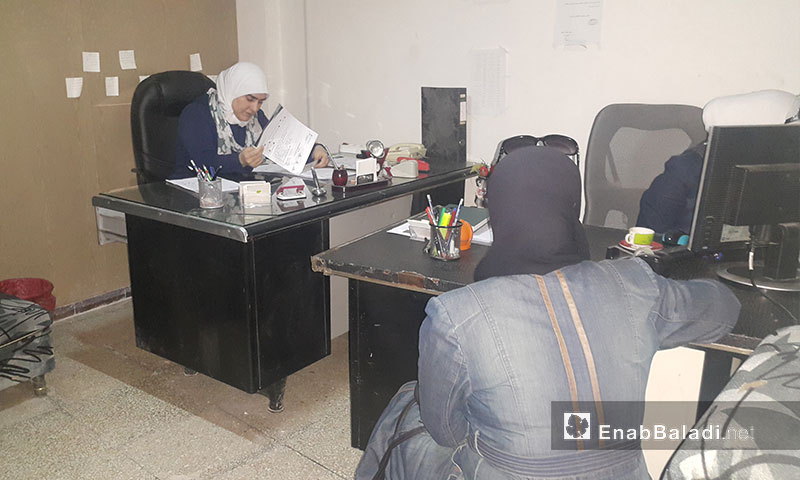 The head of the Women’s Bureau of the Duma local council, Bayan Rayhan, receives women registered in the Karama project for grants, May 21, 2017 (Enab Baladi)