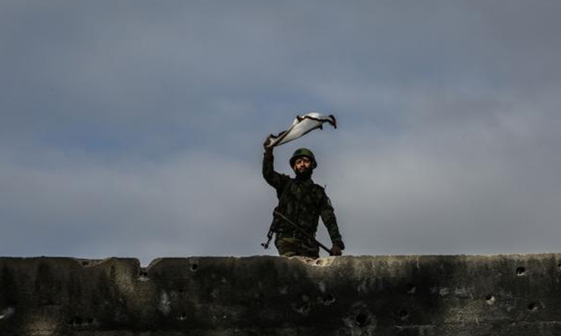 A cadet in the Jaish al-Islam Military Academy waves the academy's flag during a drill in January. The opposition group supervises a prison in the eastern suburbs of Damascus that is notorious for its abuse and torture methods. Photo by Mohammed Badra/EPA