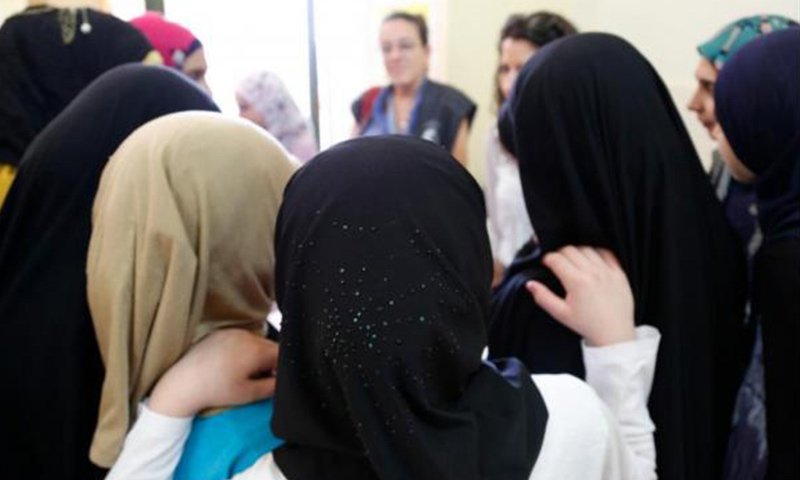 Syrian and Lebanese girls huddle round in a group discussion about early marriage at a community center in southern Lebanon in 2014. Photo by Russell Watkins/Department for International Development