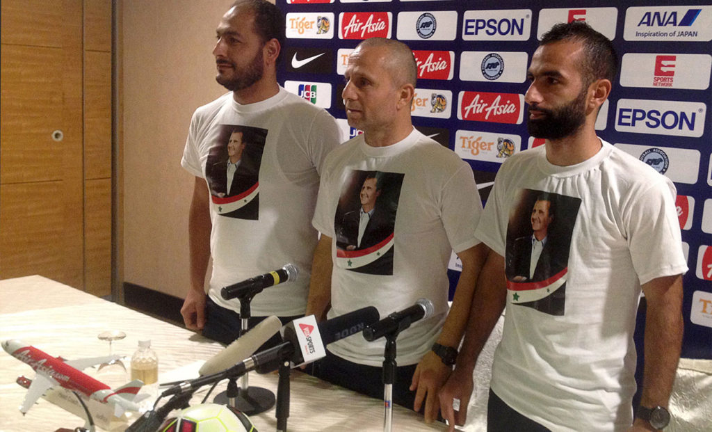Former coach of Syrian national team Fajr Ibrahim with player Usama Omri and the administrative Mohammed Bashar with pictures of Assad on their T.shirts at a conference in Singapore in 2015 (press conference)