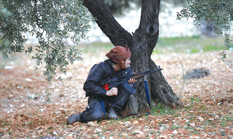 A Free Army Fighter clashing with officers of al- Assad forces in the vicinity of Idlib in February 2012 (Reuters)