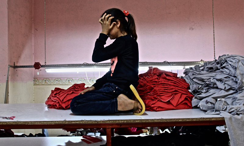A Syrian girl, 13 years old,  in the Turkish city of Mersin, working in a textile factory - (groene)