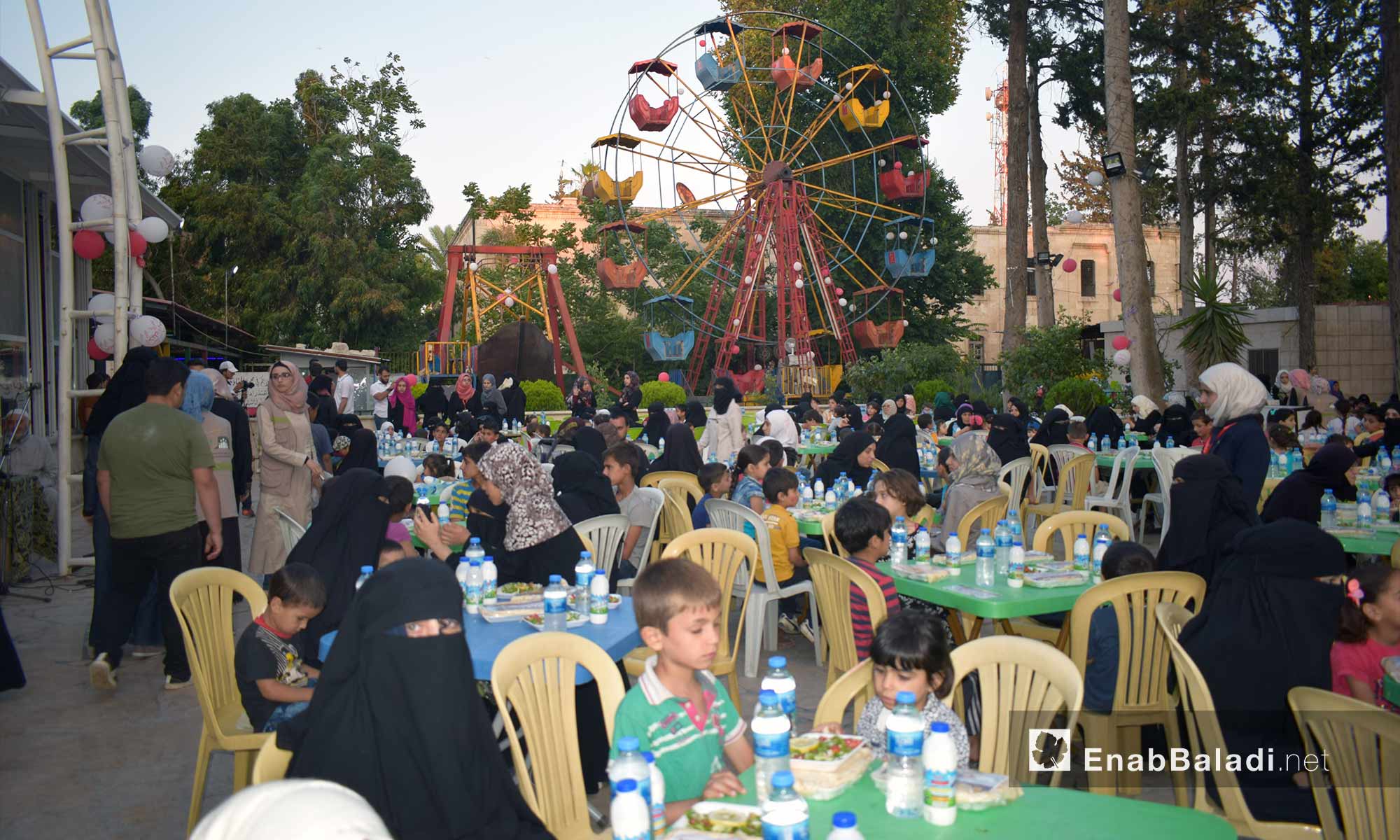 The orphans and their mothers having the Iftar meal at the Family Club in Idlib – May 30, 2018 (Enab Baladi)