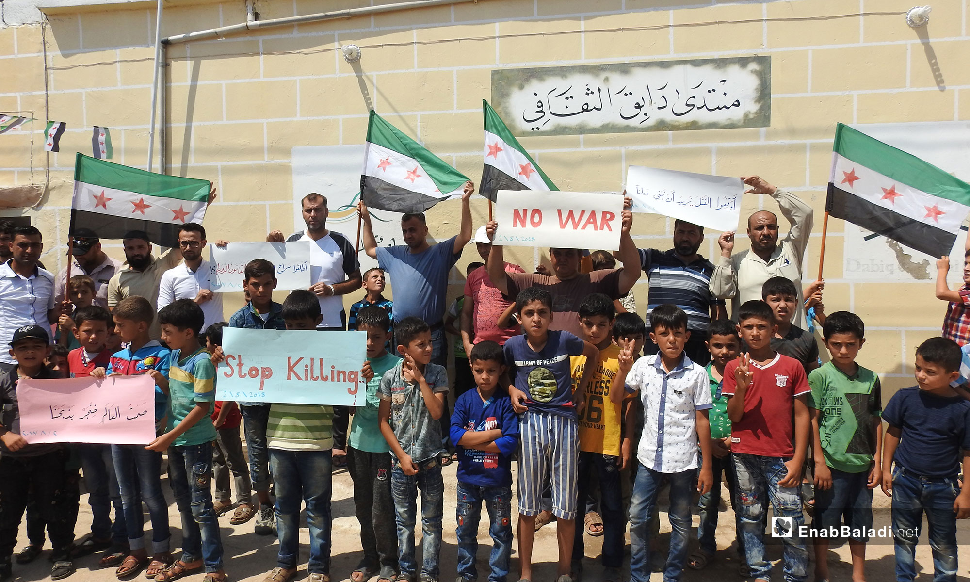 A Sit-in in the town of Dabiq protesting the violations of Syrian detainees’ rights, northern rural Aleppo (Signs in Arabic say: Stop killing, we want to build a homeland, the world’s silence is a dagger killing us) – August 2, 2018 (Enab Baladi)