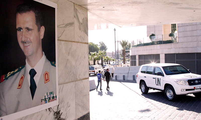 A UN vehicle is seen near a photo of Bashar al-Assad at the entrance of a hotel where a team of experts stayed in Damascus October 8, 2013. (Reuters)