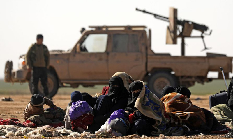 Civilians escaping the fight against the Islamic State in the east of the Euphrates, behind them is SDF fighter – February 3, 2019 (AFP)