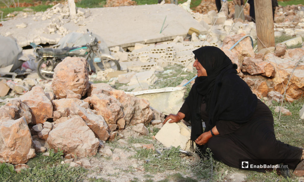 A woman sitting on the rubble of her house after it was shelled by the Russian aircraft in the town of Faqie, southern Idlib – March 21, 2019 (Enab Baladi)