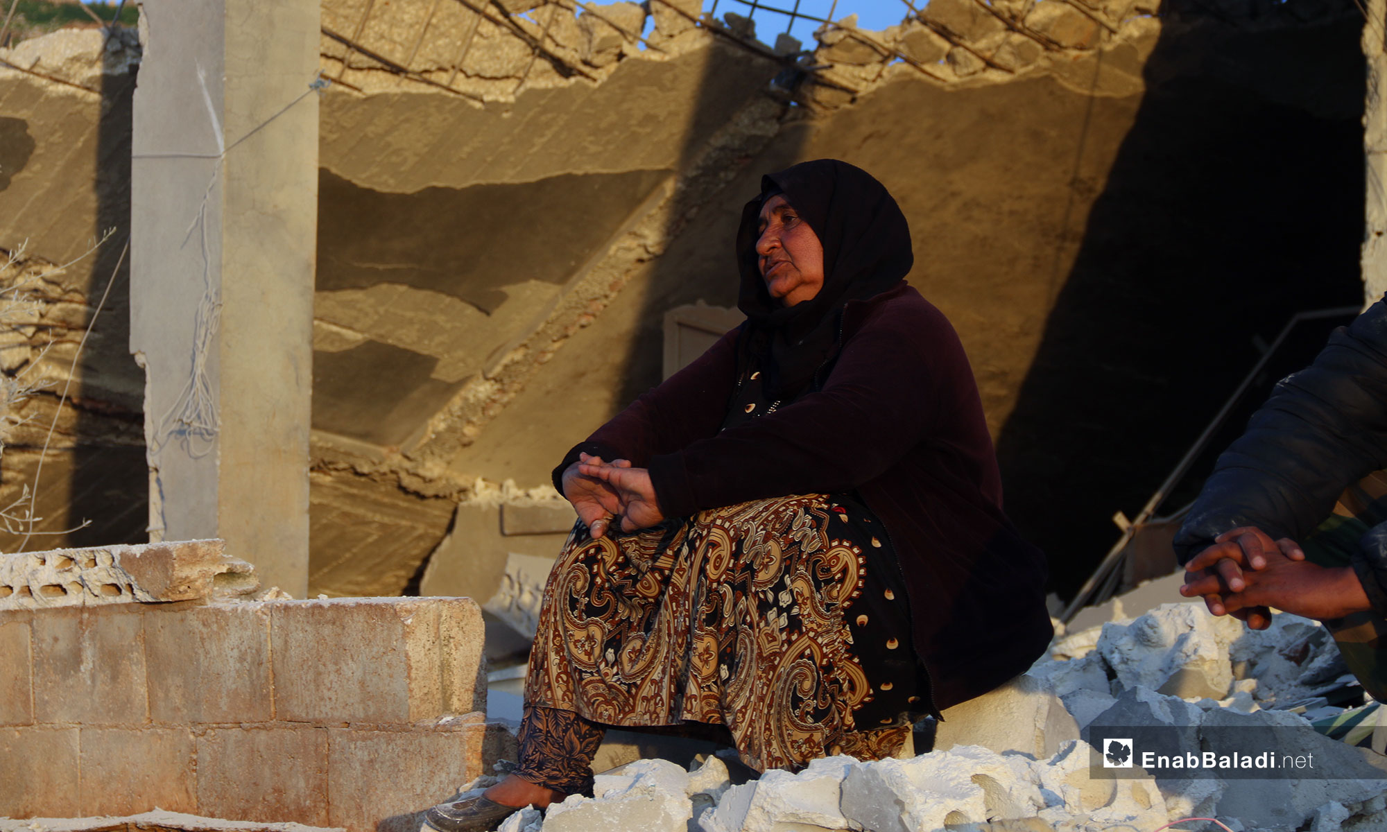 A woman sitting on the rubble of her house after it was shelled by the Russian aircraft in the town of Faqie, southern Idlib – March 21, 2019 (Enab Baladi)