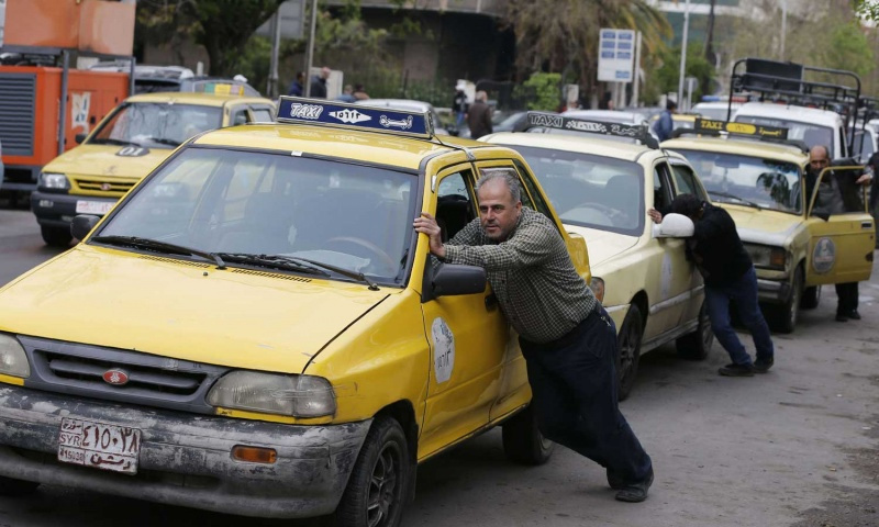 Taxi drivers pushing their cars which are run out of fuel to the Filling Station, Damascus – April 16, 2019 (AFP)