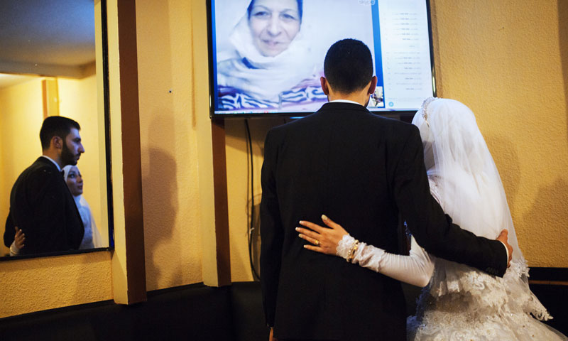 The bride and groom, Salsabeel and Bilal, on a Skype call with their families in Damascus and Wadi Barada (alessiomam)