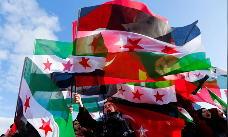 People waving Turkish and Syrian flags before the departure of an aid convoy headed for Syria - 2016 (Reuters)