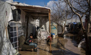 A Syrian child refugee sitting in front of his family’s tent, which water has drowned in the al-Dalhamiyya Camp, eastern Lebanon – January 15, 2019 (UNHCR)