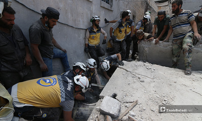 The Syrian Civil Defense pulls victims out of the rubble in the wake of the aerial shelling on Ariha, southern Idlib – July 12, 2019 (Enab Baladi)