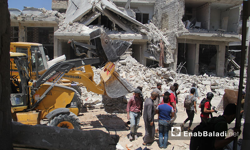 Volunteers of Syrian Civil Defense pulling out civilians from debris of houses destroyed by Russian air raids on Ma`arat al-Nu`man, Idlib – July 22, 2019 (Enab Baladi)