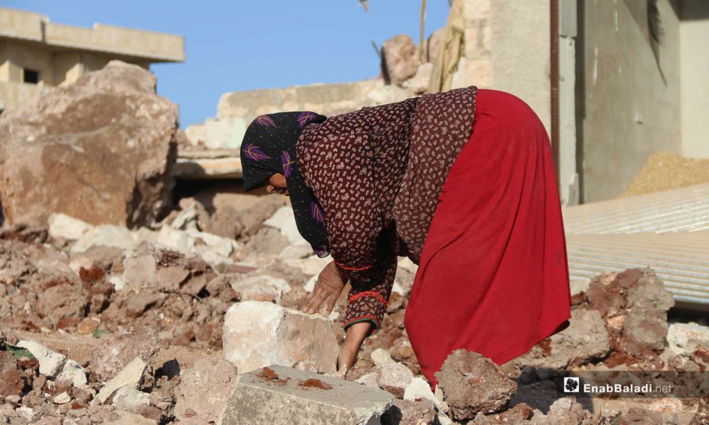 A woman among the debris of her house, hit by a Russian air raid in Kafr Nabl, Idlib – May 20, 2019 (Enab Baladi)