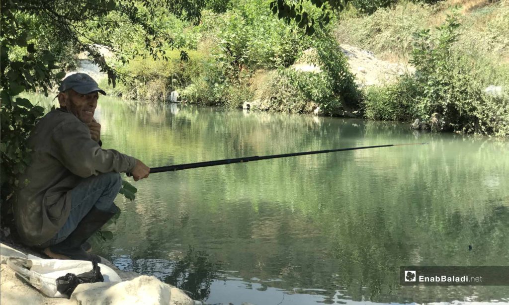 A man fishing in the Assi River, near the city of Darkoush, western rural Idlib -September 8, 2019 (Enab Baladi)