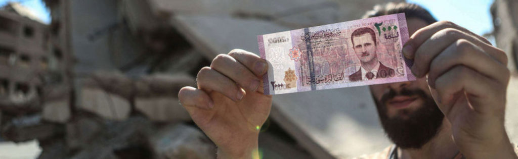A Syrian man carrying a 2,000 Syrian pounds banknote. (shutterstock)
