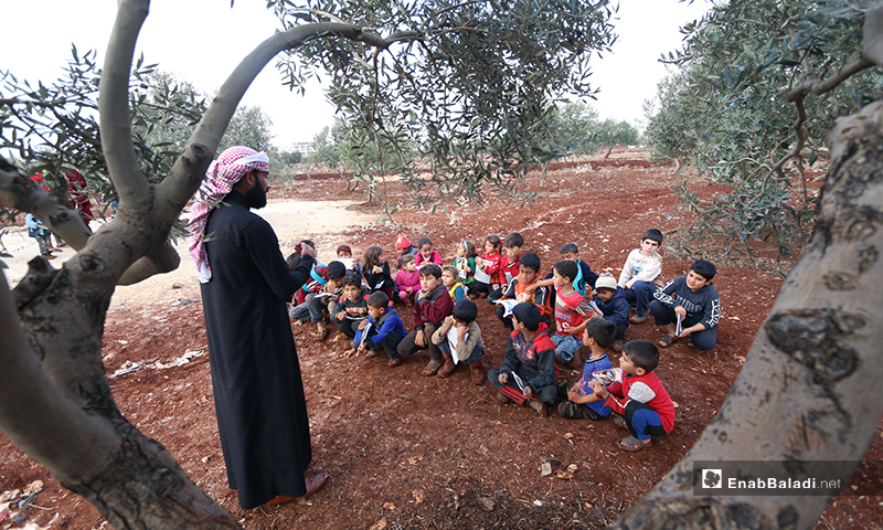 A wall-less school under olive trees in Senjar refugee camp in the northern countryside of Idlib –3 December 2019 (Enab Baladi)