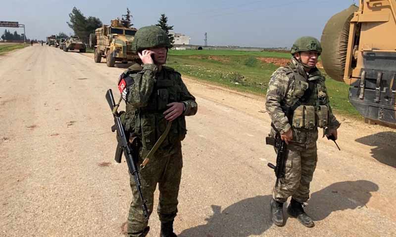 Two officers of the Russian and Turkish armed forces on the "M4" highway in Idlib countryside (Turkish Ministry of Defense)