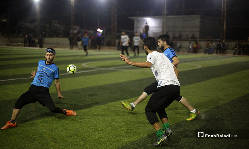 Two players trying to control the ball in the final match of the North Stars League between Deir Hassan and Akrabat teams in Kah area in Idlib – 03 May 2020 (Enab Baladi)