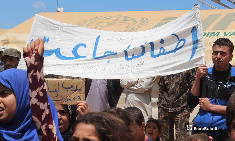“Our children are starving,” a banner carried by a displaced child during the demonstration of al-Omran camp, west of Haranabush - 10 May (Enab Baladi)
