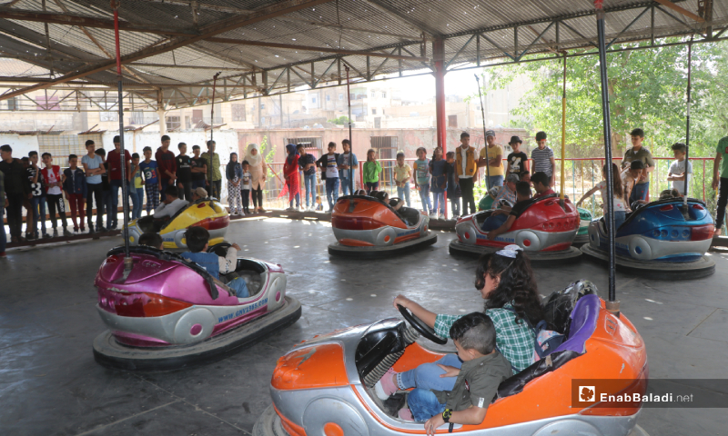 Children having fun while riding electric bumper cars at the amusement park of al-Raqqa province during Eid al-Fitr holiday – 26 May 2020 (Enab Baladi)
