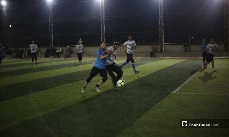 
Two players trying to control the ball in the final match of the North Stars League between Deir Hassan and Akrabat teams in Kah area in Idlib – 03 May 2020 (Enab Baladi)
