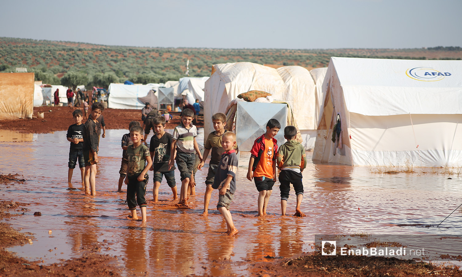 Children of “Sahl al-Khair” camp for Syrian internally displaced people (IDPs) after the rainstorm near Kafr Bunni in northern Idlib countryside – 19 June 2020  (Enab Baladi / Yousef Ghuraibi)