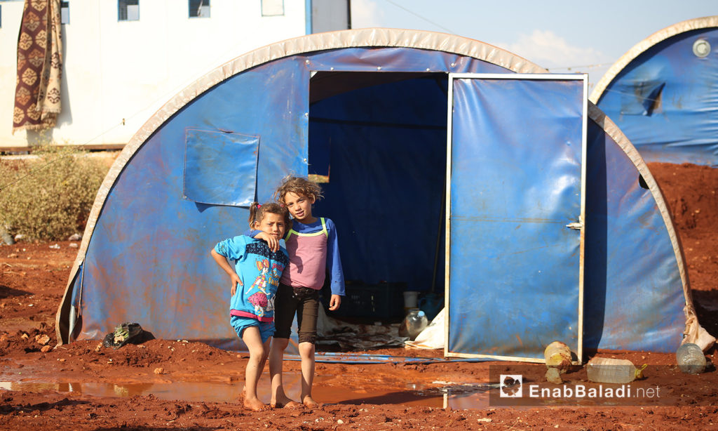 Two children in front of their tent at “Sahl al-Khair2 camp for Syrian internally displaced people (IDPs) after the rainstorm near Kafr Bunni in northern Idlib countryside – 19 June 2020 (Enab Baladi / Yousef Ghuraibi)