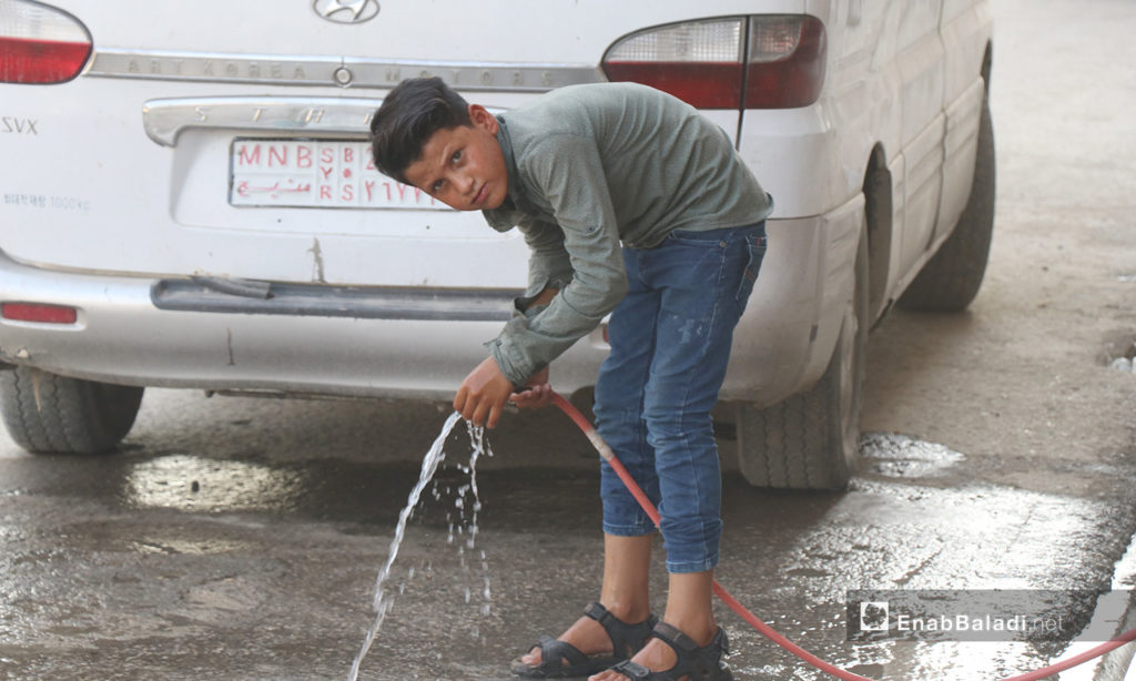 A child playing with water in al-Raqqa city – 26 July 2020 (Enab Baladi / Abdul Aziz Saleh)