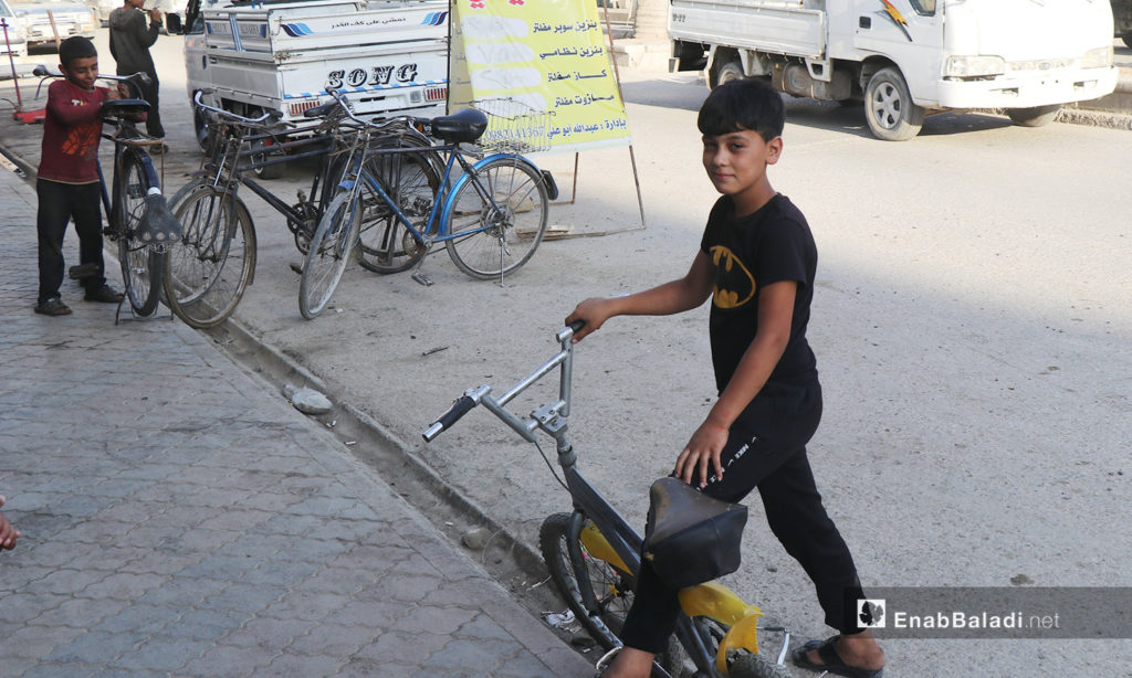 A child with his bicycle in al-Raqqa city – 26 July 2020 (Enab Baladi / Abdul Aziz Saleh)